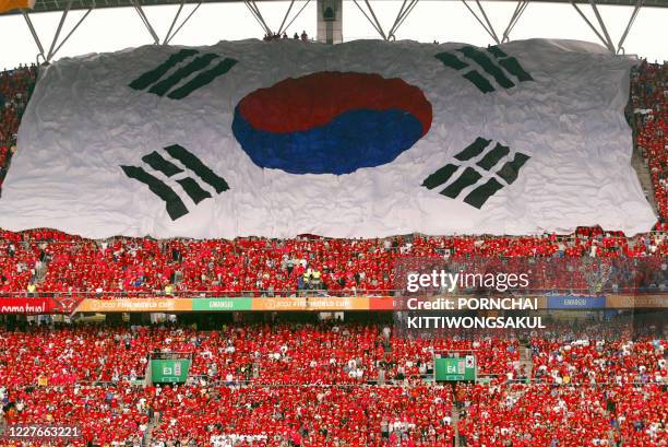 The South Korean national flag flies over a carpet of fans all dressed in red in support of their team prior to the start of their quarter-final...