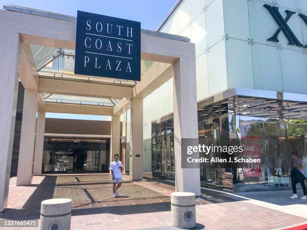 Shoppers wearing masks come and go from South Coast Plaza Monday, which will be closed down Tuesday for a second time by Gov. Newsom in an attempt to...