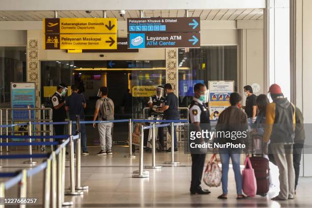 Securities checks passengers documents before entering departure gate during new normal era at domestic terminal of I Gusti Ngurah Rai International...