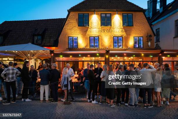 People stand in line without social distancing outside a restaurant on July 17, 2020 in Gotland, Sweden. Sweden largely avoided imposing strict...