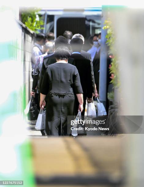 Bereaved family members and company officials leave on July 18 the site where the Kyoto Animation Co. Studio that was subjected to a deadly arson...