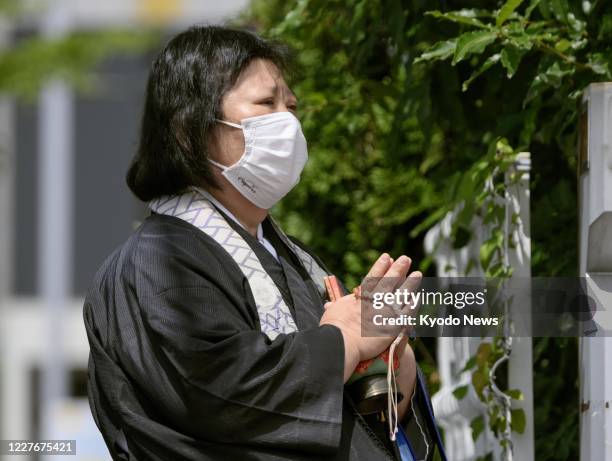 Priest prays on July 18 in front of the site where the Kyoto Animation Co. Studio that was subjected to a deadly arson attack used to stand. Bereaved...