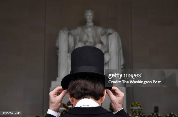 George Buss of Freeport, IL adjusts his hat as he portrays President Abraham Lincoln during a commemoration of Lincoln's birthday at the Lincoln...