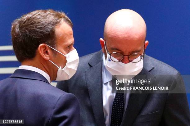 France's President Emmanuel Macron speaks with President of the European Council Charles Michel during an EU summit at the European Council building...
