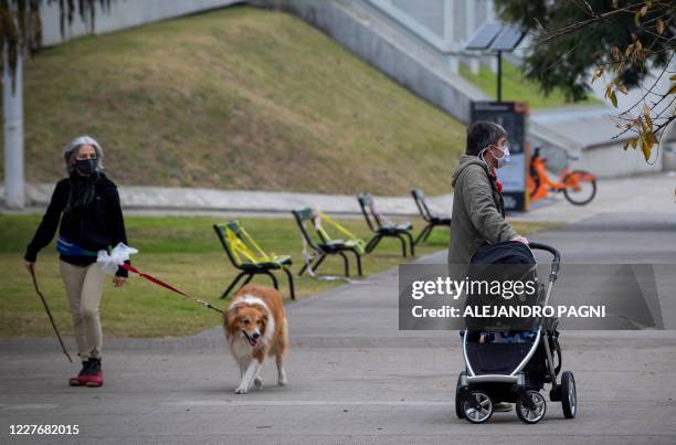 People take a walk in Buenos Aires on July 18, 2020 a day after Argentina's government announced it was relaxing coronavirus containment measures in...