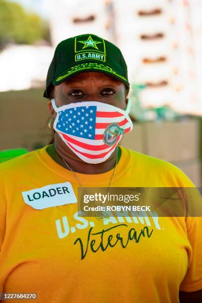 Food bank volunteer Ann Duson poses for a photo wearing an American flag mask at a free community food bank in the Crenshaw neighborhood of Los...