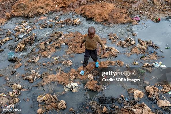 A boy is seen playing in a polluted drainage ditch in Kibera...