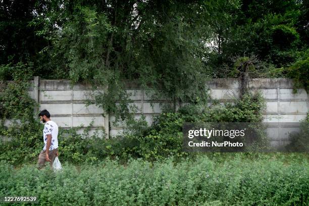 Migrant from Pakistan is walking in the back of the Cpr with a bag carrying food to be cooked into the woods in Gradisca d'Isonzo, Italy, on July 18,...