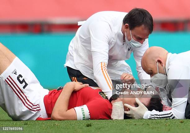 Manchester United's English defender Harry Maguire recieves treatment to a head injury during the English FA Cup semi-final football match between...