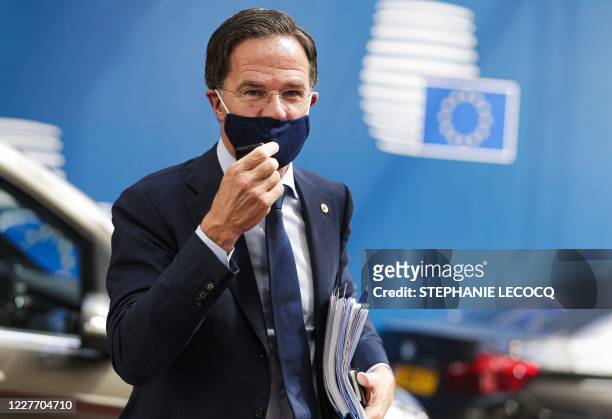 Netherlands' Prime Minister Mark Rutte adjusts his protective face mask, as he arrives for the fourth day of an EU summit at the European Council...