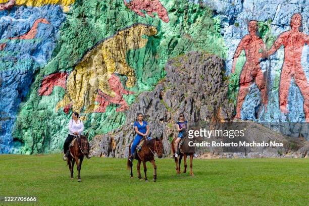 Tourists riding rented horses in the Prehistory Mural located in the Vinales Valley which is a Unesco World Heritage Site.