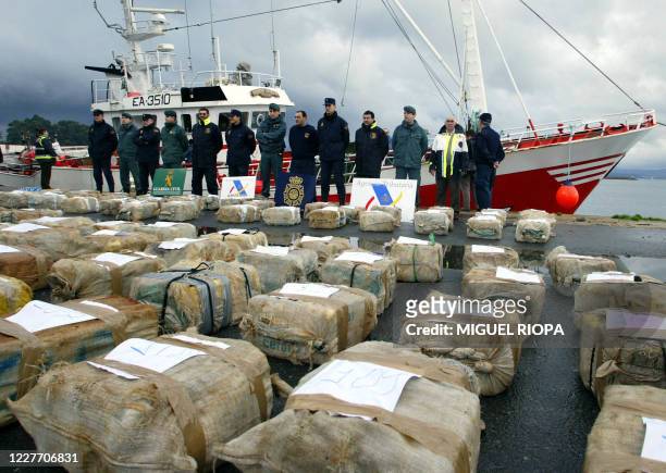 Group of policemen stand near packs of drug bags confiscated from the "Playa de Arbeyal" vessel, in Vilagarcia de Arousa port, northwestern Spain, 07...