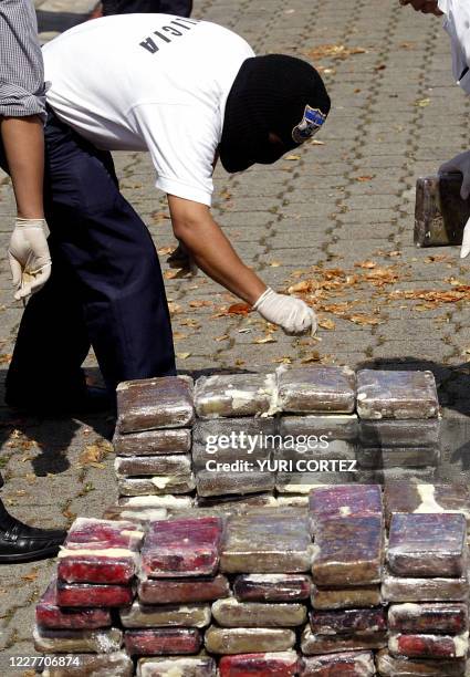 Un miembro de la división antinarcóticos de la Policía Civil, inspecciona el 28 de octubre de 2004 en San Salvdor, parte de los más de 500 kgs de...
