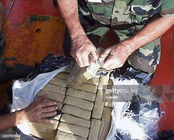 Des membres de la marine nationale manipulent des paquets contenant de la cocaïne, le 28 juillet 2001 au large des côtes de Guyane, à bord du...