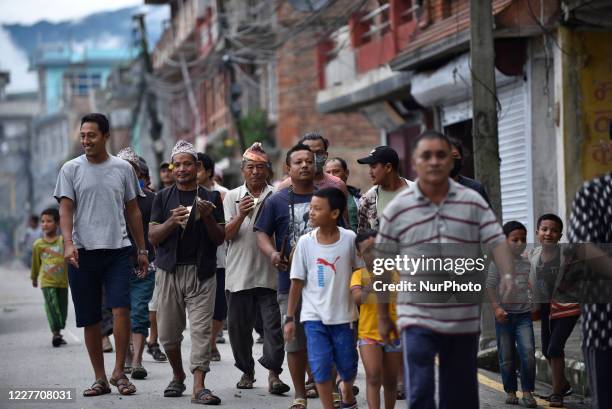 Nepalese devotees playing traditional instruments as carrying straw effigy of the demon Ghantakarna during the Gathemangal festival celebrated at...