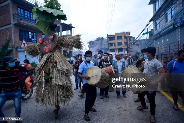 Nepalese devotee carrying straw effigy demon Ghantakarna during the Gathemangal festival celebrated at Bhaktapur, Nepal Sunday, July 19, 2020....