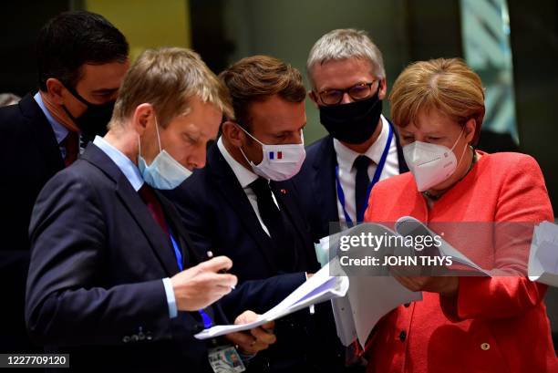 Spain's Prime Minister Pedro Sanchez , French President Emmanuel Macron and German Chancellor Angela Merkel look into documents during an EU summit...