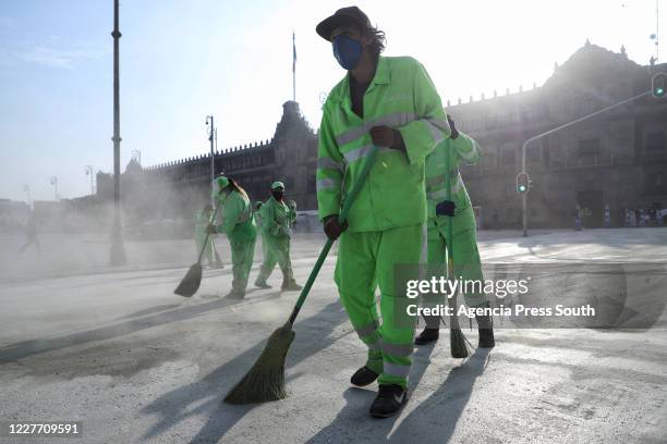 Group of workers sweep the square during maintenance work to replace the asphalt around the Plaza de la Constitucion at Zocalo on July 20, 2020 in...