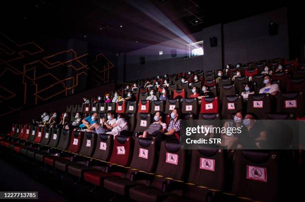 This photo taken on July 20, 2020 shows people watching a movie as they sit apart to ensure social distancing on the first day of the re-opening of...