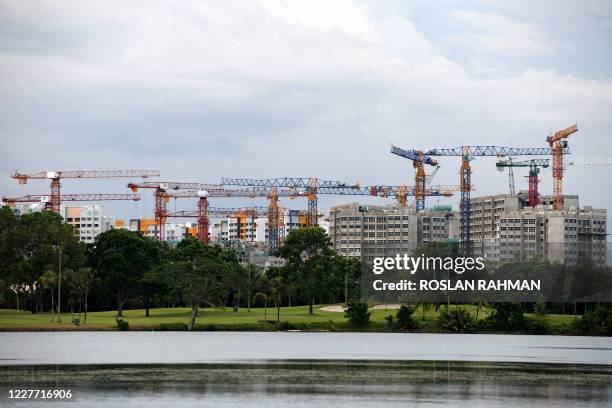 Cranes are seen amid public housing units still under construction in Singapore on July 21, 2020.