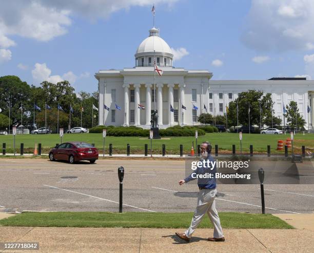 Pedestrian speaks on a smartphone while passing in front of the Alabama Capitol in Montgomery, Alabama, U.S., on Monday, July 20, 2020. Hospitals in...