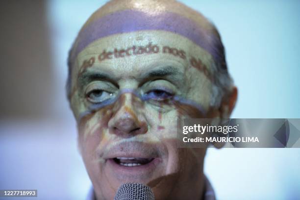 Video projection partially covers the face of Jose Serra, presidential candidate for the Brazilian Social Democratic Party , as he speaks during a...