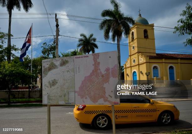 Taxi drives near a church in Vinales, Pinar del Rio Province, Cuba, on July 21, 2020. - Cuba -which has 2446 confirmed cases of Covid-19 and 87...