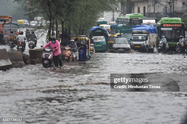 Commuters make their way past heavy water logging after a spell of rain at Anand Parbat, on July 21, 2020 in New Delhi, India. Heavy downpour Monday...