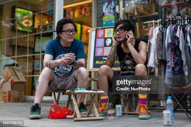 Beijing, China, the 20 June, 2011. Young men chill in the street in the Houhai neighborhood.