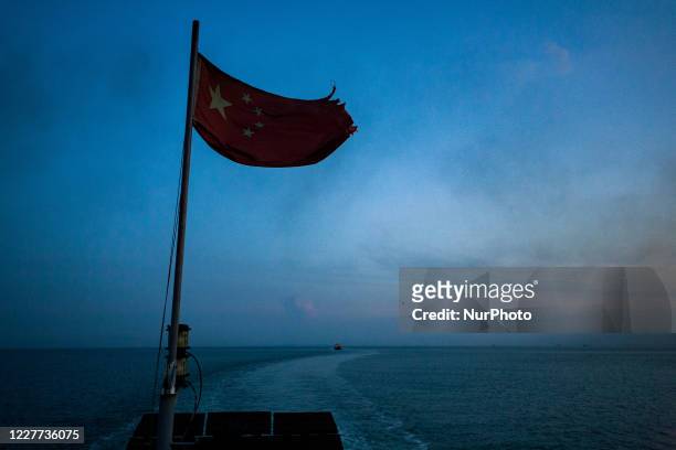 Sanya, China, the 7 august 2011. The chinese flag on a boat in the South China Sea. It is a marginal sea that is part of the Pacific Ocean. The...