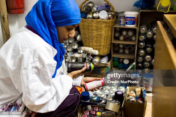 Sfax, Tunisia, 2 November 2016. Oumema choose spray paints from her workshop before going out.