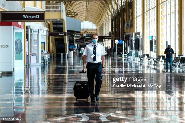 Pilot walks through the terminal at the Ronald Reagan National Airport on July 22, 2020 in Arlington, Virginia. During the COVID-19 pandemic, all...