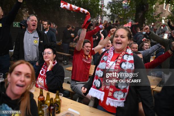 Liverpool fans celebrates their team's first goal as they watch a big screen showing Liverpool's final home English Premier League football match of...