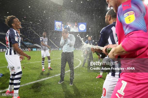 Champagne soaked Slaven Bilic head coach / manager of West Bromwich Albion as the team celebrate promotion to the Premier League on the pitch at the...