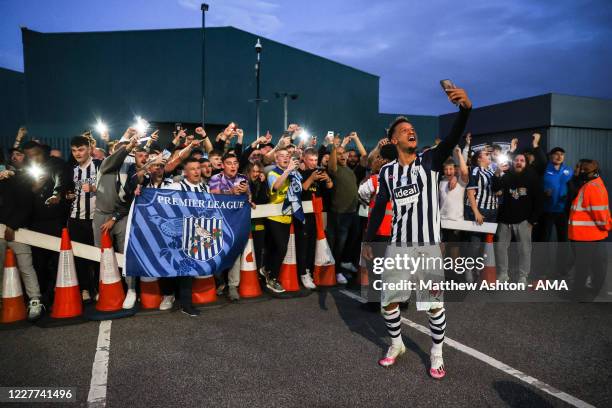 Callum Robinson of West Bromwich Albion celebrates with the fans outside as promotion to the Premier League is confirmed on the final day during the...