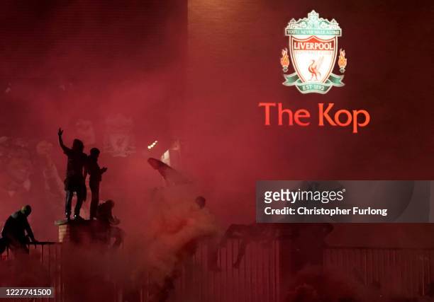 Liverpool fans celebrate outside The Kop stand at Anfield stadium during the Premier League match between Liverpool and Chelsea on July 22, 2020 in...