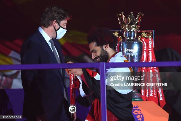 Liverpool's Egyptian midfielder Mohamed Salah recieves his Premier League winner medals during the presentation following the English Premier League...