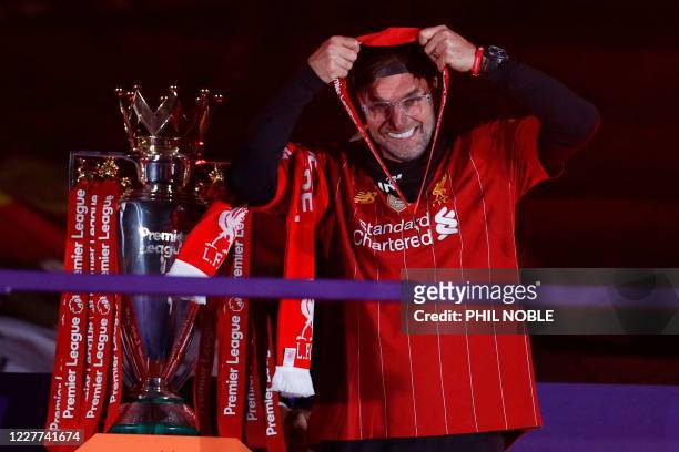 Liverpool's German manager Jurgen Klopp recieves his medal next to the Premier League trophy during the presentation following the English Premier...