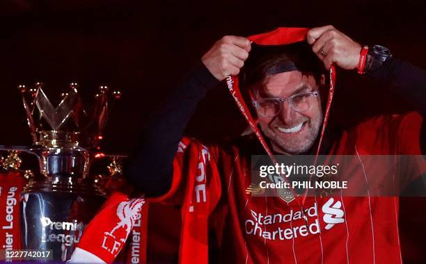 Liverpool's German manager Jurgen Klopp recieves his medal next to the Premier League trophy during the presentation following the English Premier...