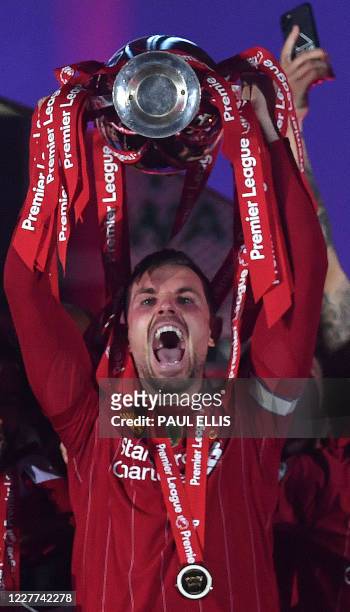 Liverpool's English midfielder Jordan Henderson lifts the Premier League trophy during the presentation following the English Premier League football...