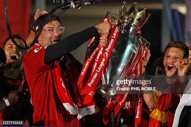 Liverpool's German manager Jurgen Klopp and Liverpool's English midfielder Adam Lallana pose with the Premier League trophy during the presentation...