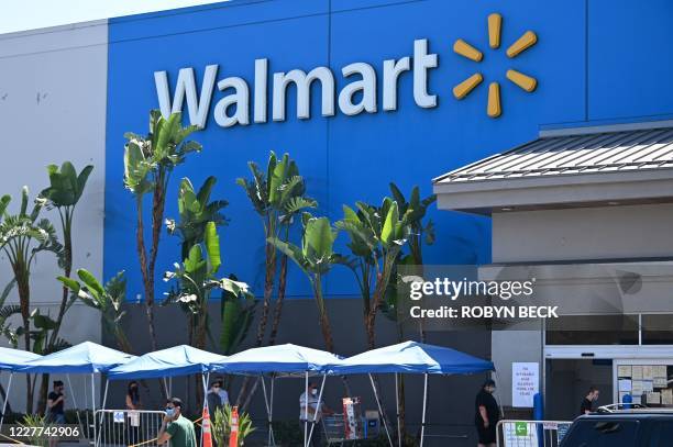People wearing face coverings wait in line to shop at Walmart, July 22, 2020 in Burbank, California. - The country's most populous state reported a...