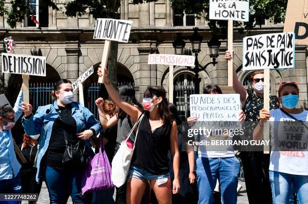 Women hold signs reading "Shame" and "Resign" during a protest organised by "Nous Toutes" feminist organisation and Europe Ecologie Les Verts Paris'...