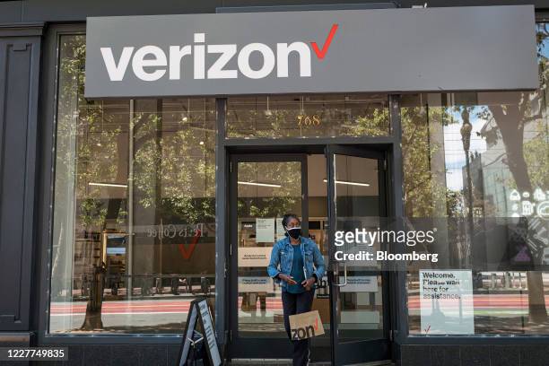 Shopper wearing a protective mask carries a shopping bag while exiting a Verizon Communications Inc. Store on Market Street in San Francisco,...