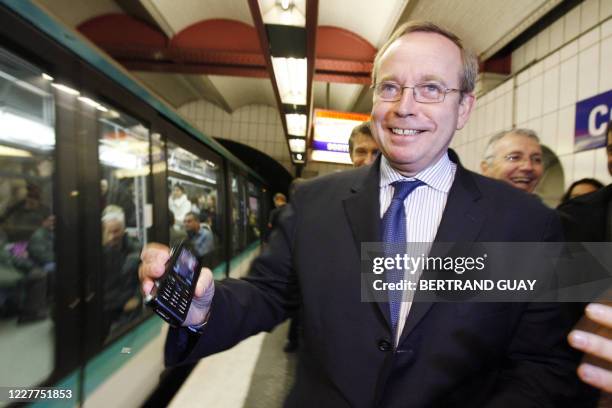 Le ministre de la Culture, Renaud Donnedieu de Vabres, présente le 08 novembre 2006 à la station Concorde du métro parisien, un téléphone mobile qui...