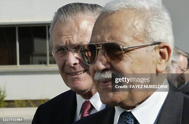 Algerian Defence Minister Abdelmalek Guenaizia escorts US Defence Secretary Donald Rumsfeld during their meeting in Algiers 12 February 2006. The...