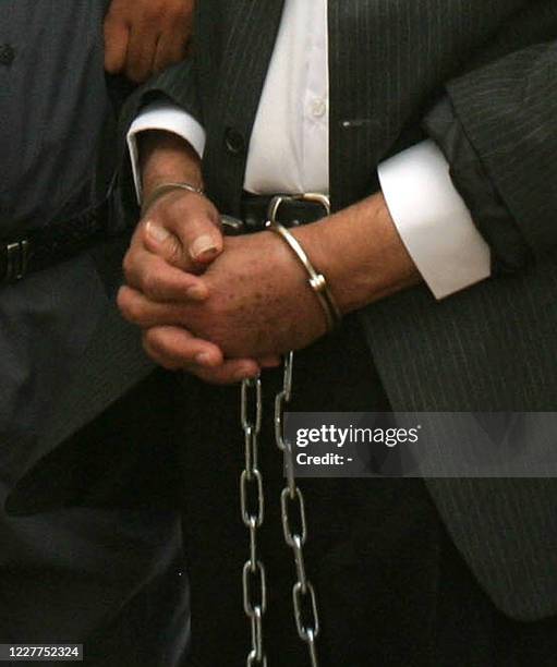 Picture released 02 July 2004 by the US Department of Defense shows shackles restraining the hands of former Iraqi president Saddam Hussein as he...