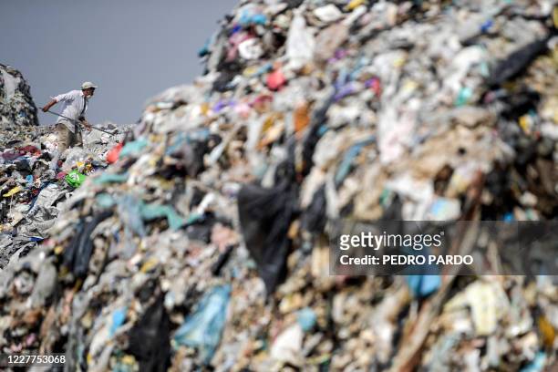 Scavenger classifies refuse at the "Bordo de Xochiaca" garbage dump in Ciudad Nezahualcoyotl, Mexico State on July 21 amid the new coronavirus...