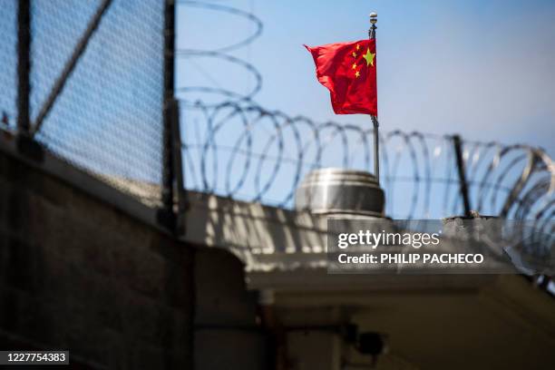 The flag of the People's Republic of China flies behind barbed wire at the Consulate General of the People's Republic of China in San Francisco,...