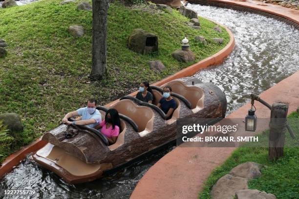 Social distancing seating measures are in place as people wearing facemasks ride Splash Mountain at Walt Disney World Resort's Magic Kingdom during...